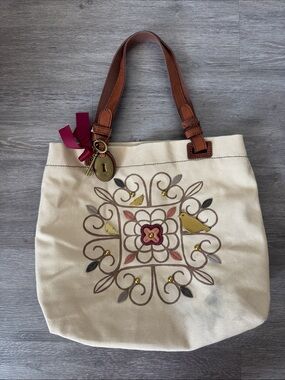 Fossil Leather and Canvas Tote Bag with Bird Motif and Charms